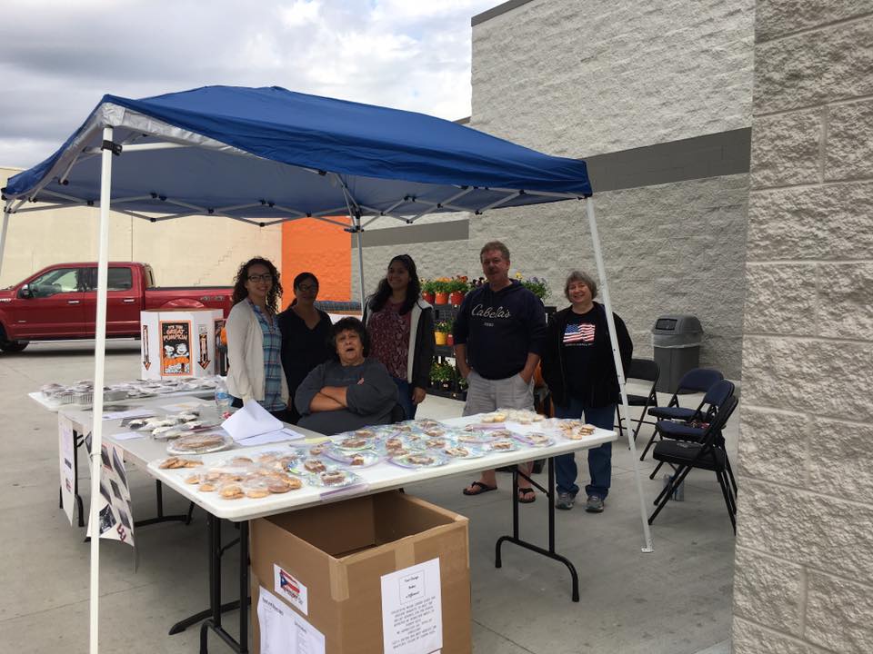 Employees under tent for bake sale